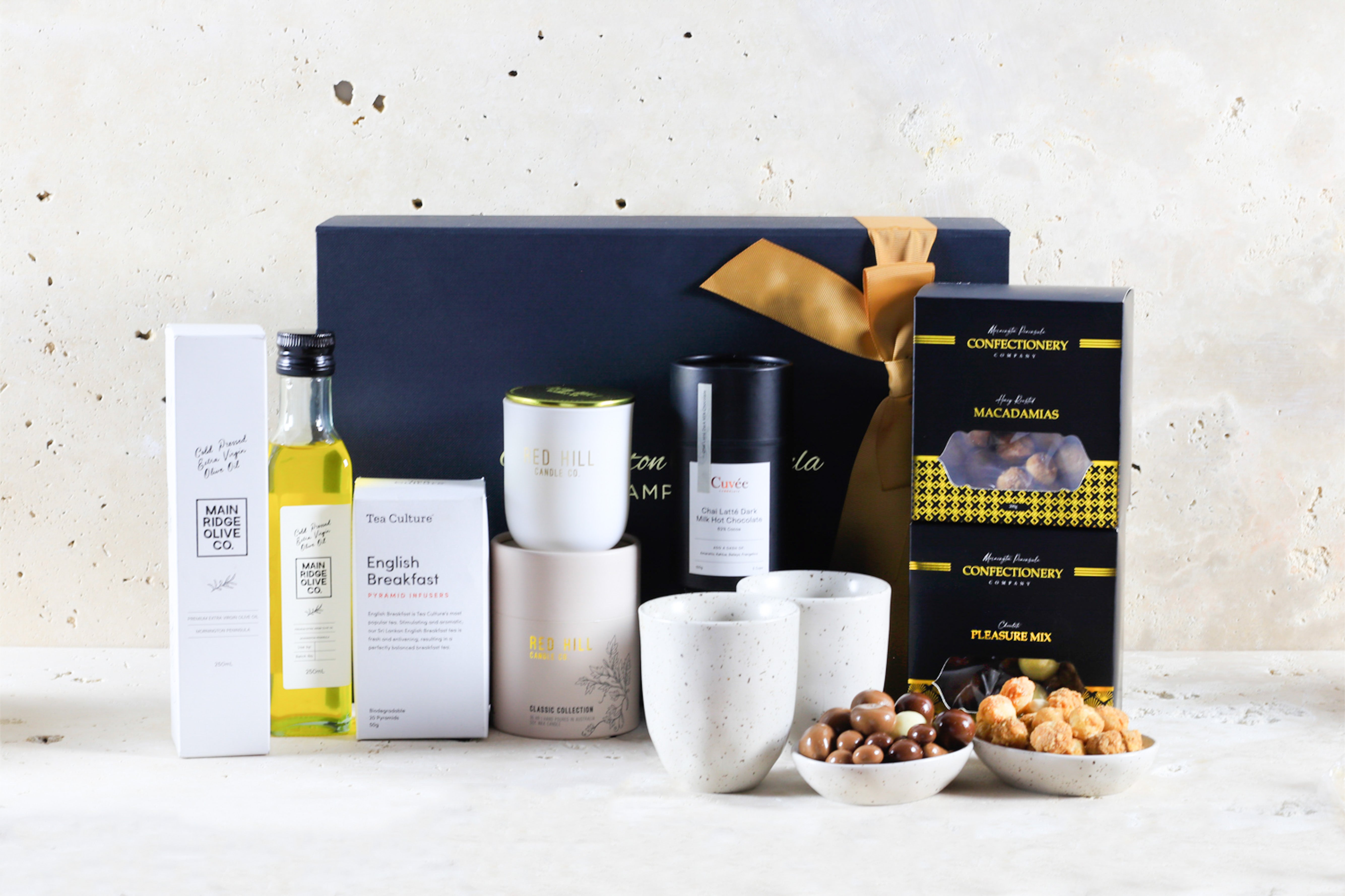 Premium tea, cups, nuts, chocolate and pantry items arranged as an elegant gift collection